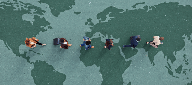 Imagem aérea de pessoas caminhando sobre um mapa-múndi, simbolizando movimento global e conexões internacionais. Ideal para temas de viagem e negócios.