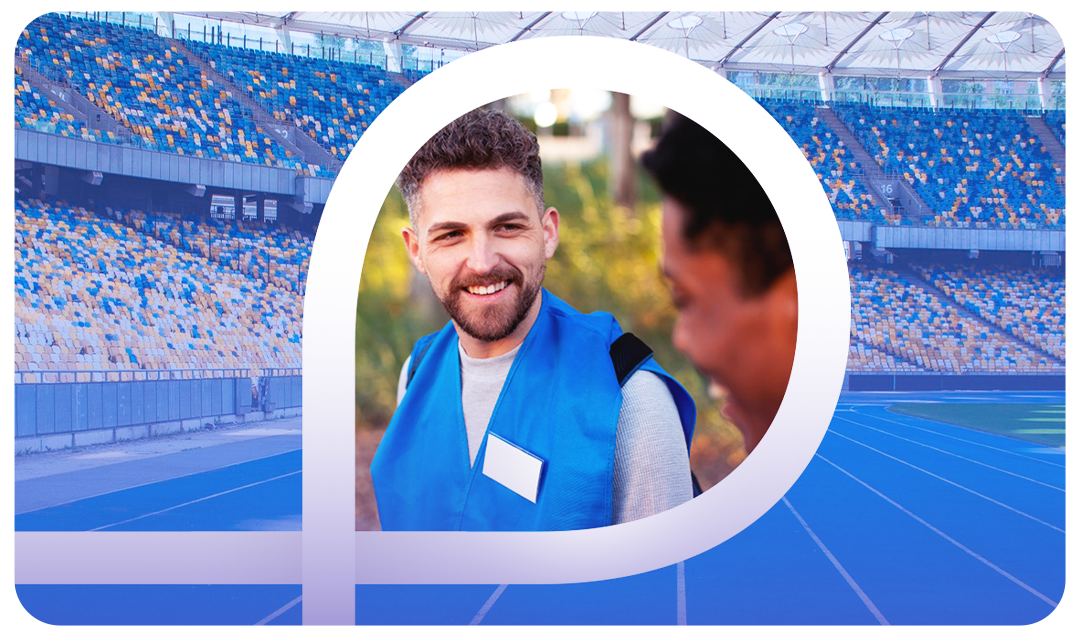 Dois homens sorrindo em um estádio de atletismo azul e branco, dentro de uma forma abstrata branca e azul.