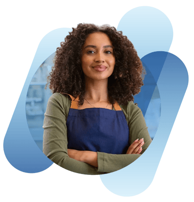 Mulher sorrindo com braços cruzados e avental azul, sobre fundo cinza com formas abstratas azuis.